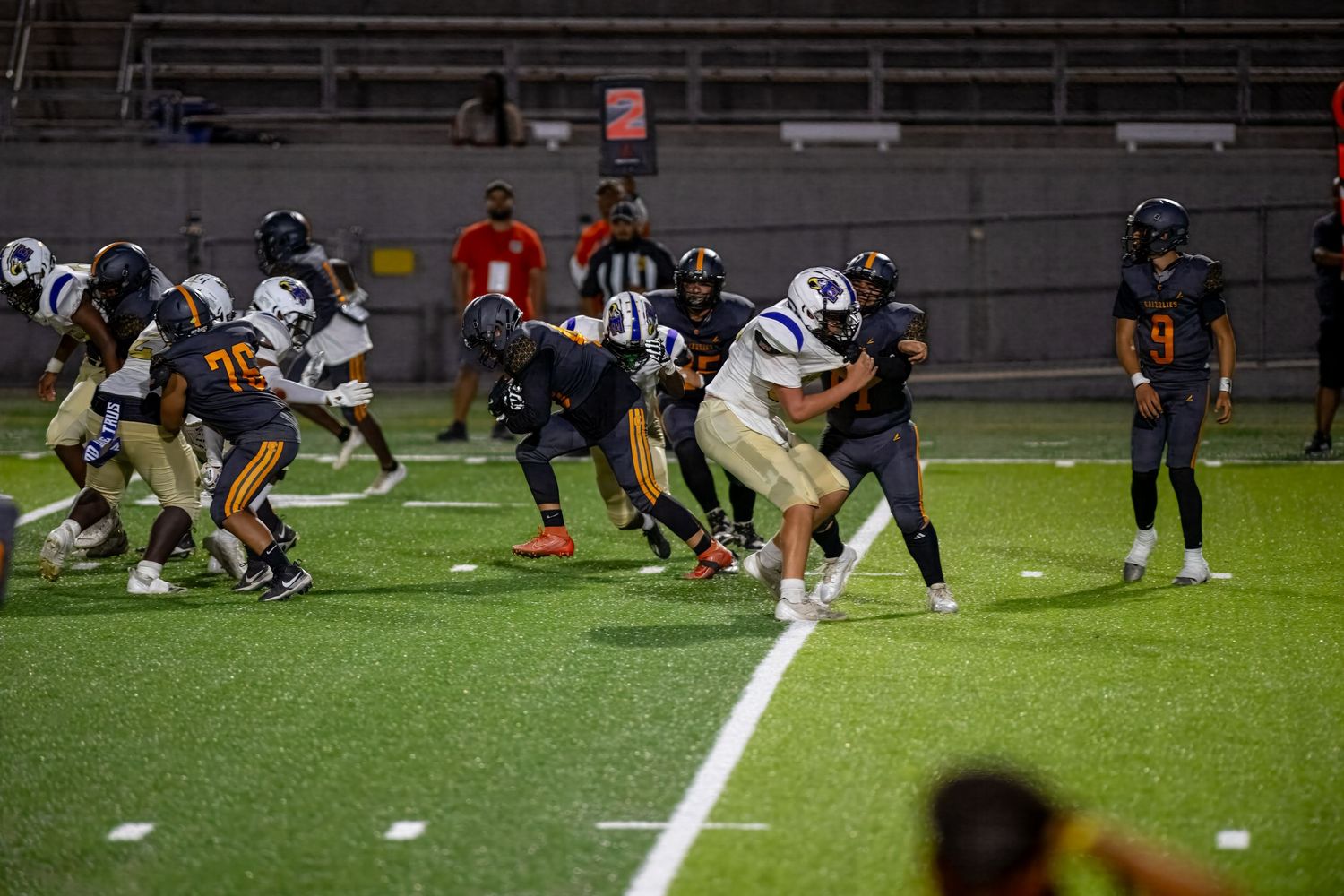 High school football players in purple uniforms competing during a game.