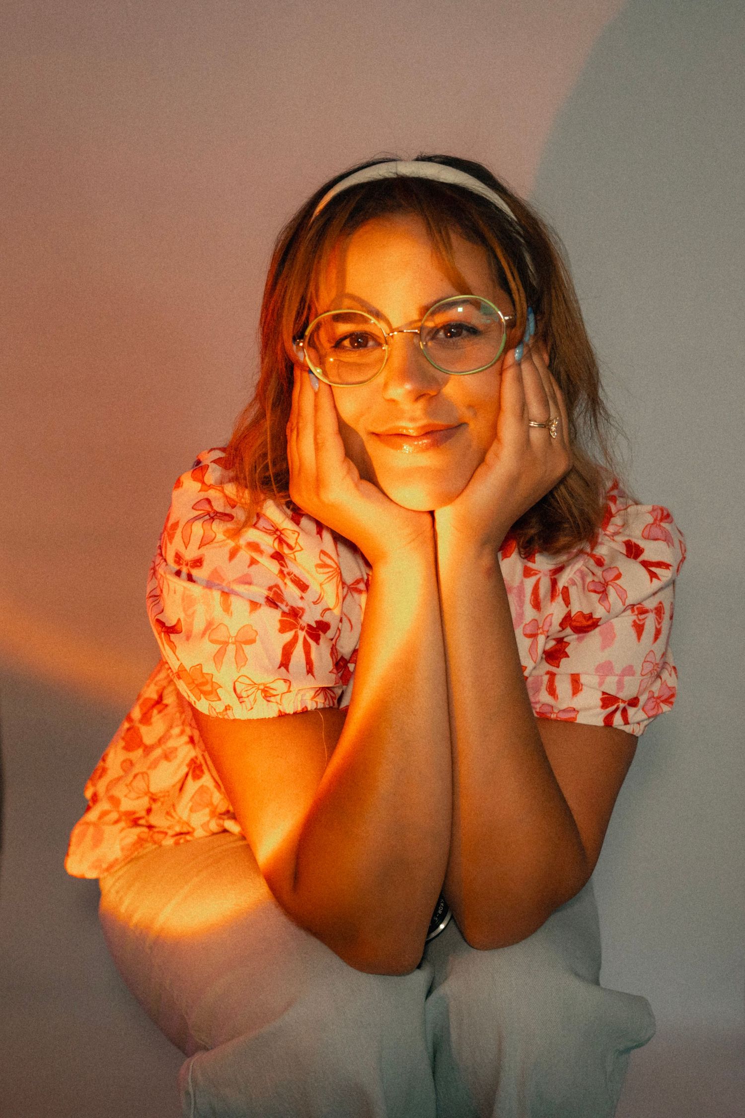Person dancing against colorful gradient wall with rainbow lighting effects.
