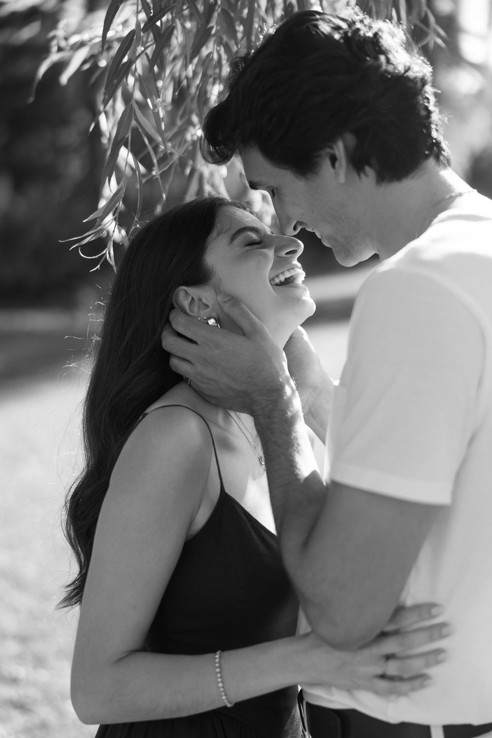 A romantic black and white photo series showing a couple embracing and sharing intimate moments in natural light.