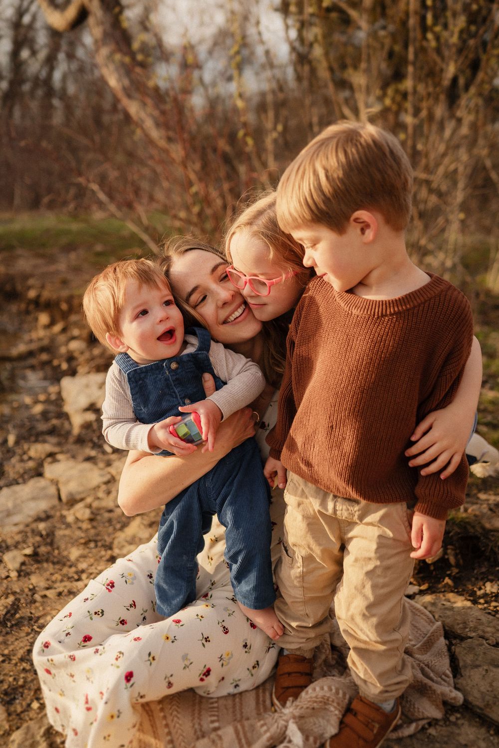 A warm autumn family portrait showing joyful embraces and laughter outdoors among fall foliage.