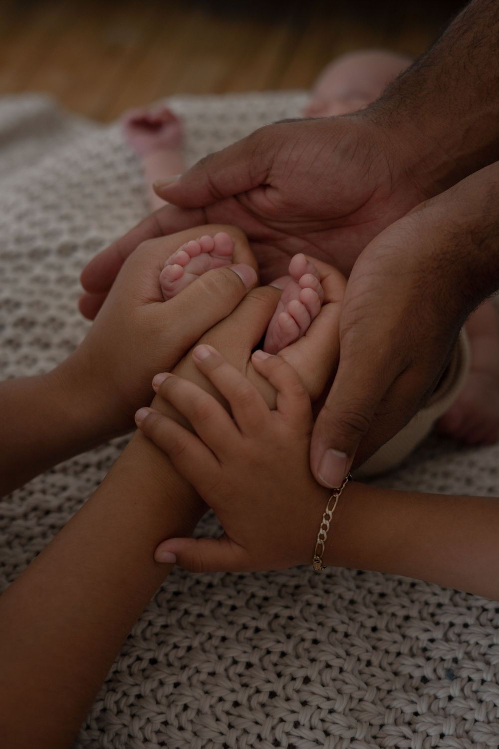 Close up of hands gently touching on textured knit blanket.