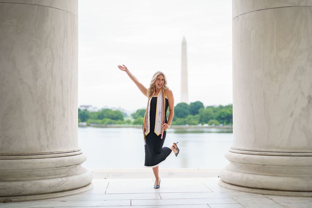 graduation session with graduate posing at the Jefferson Memorial with the Washington Monument in background, in Washington DC