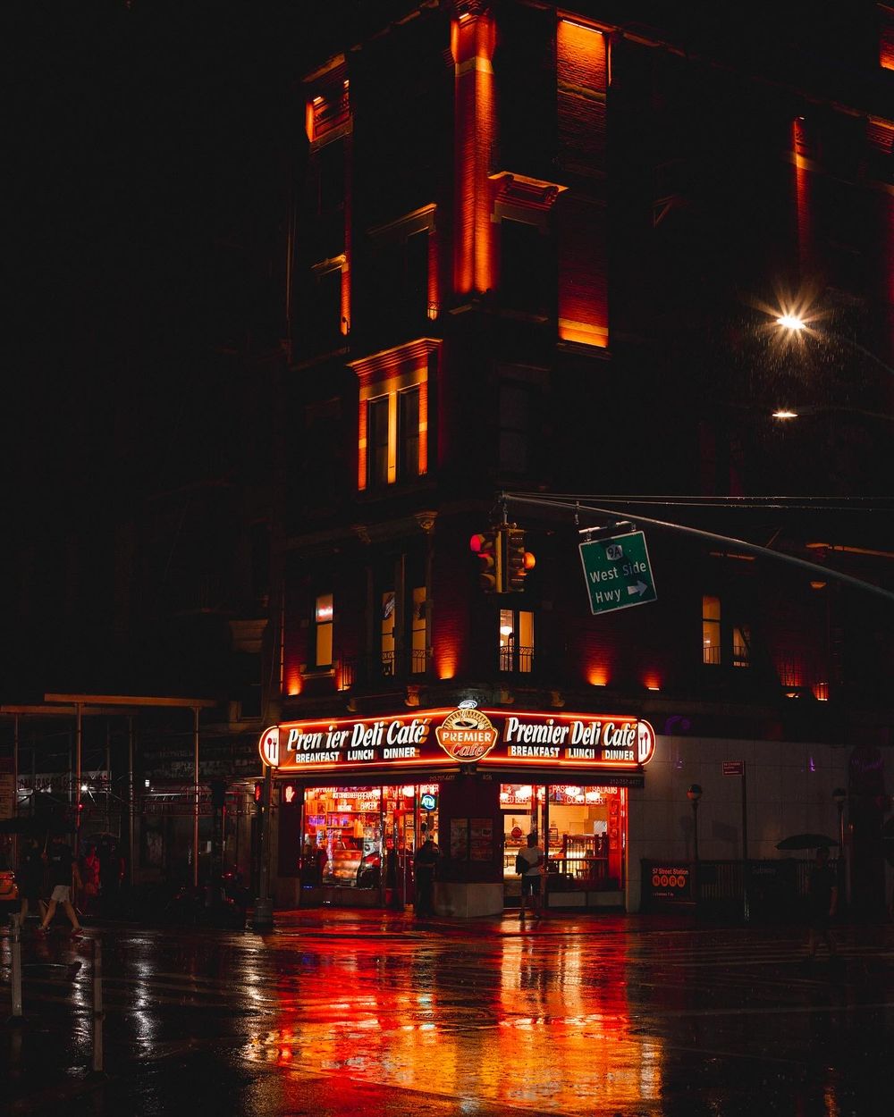 Corner store glows with warm red neon lights reflecting on wet street.