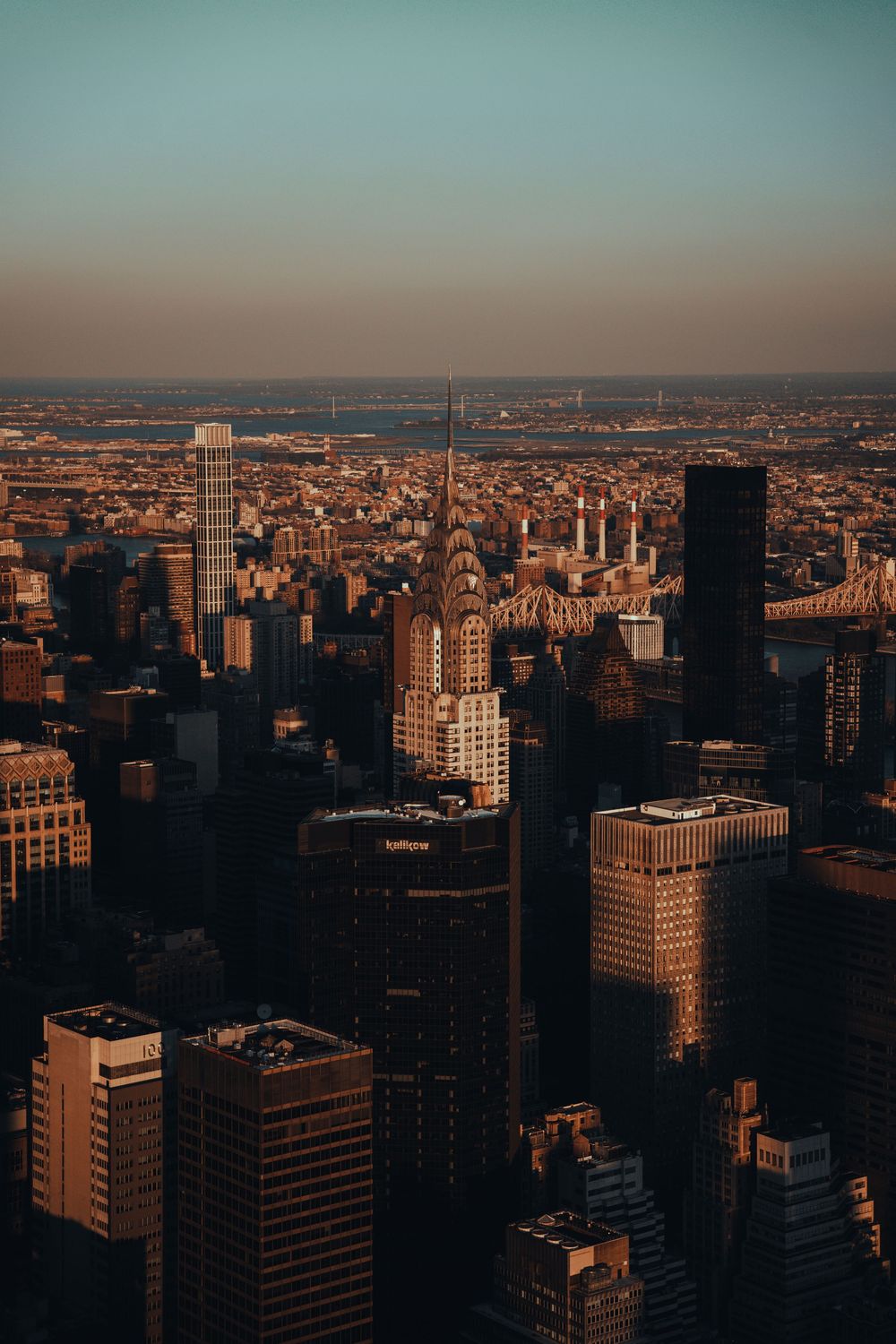 Aerial view of New York City skyline during golden hour with iconic skyscrapers.
