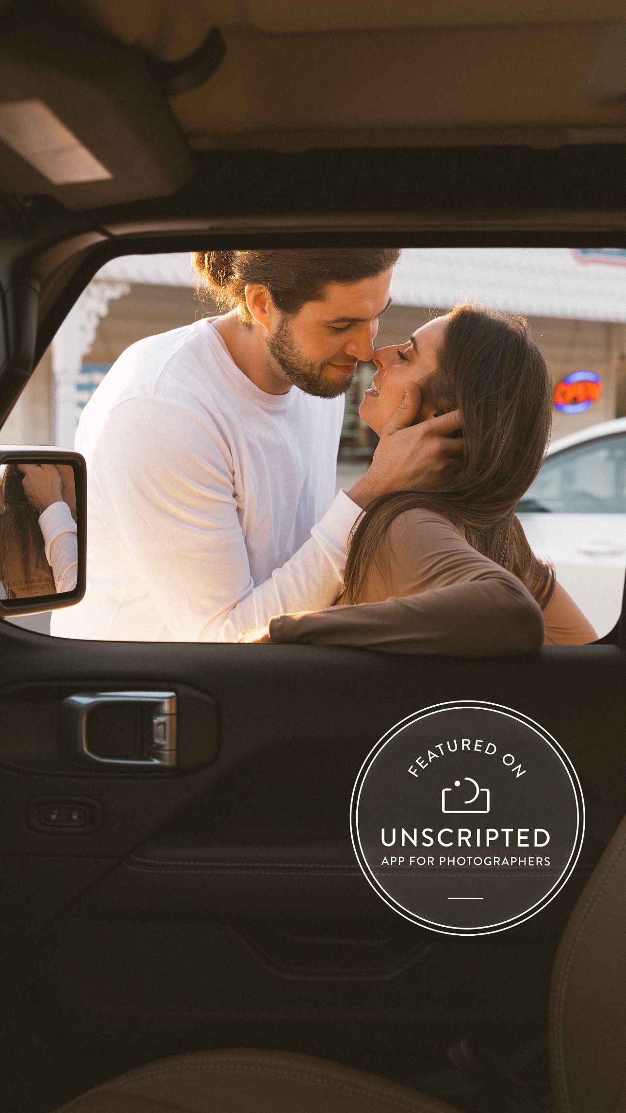 A romantic couple sharing an intimate moment in a car, with an Unscripted photography watermark overlay.