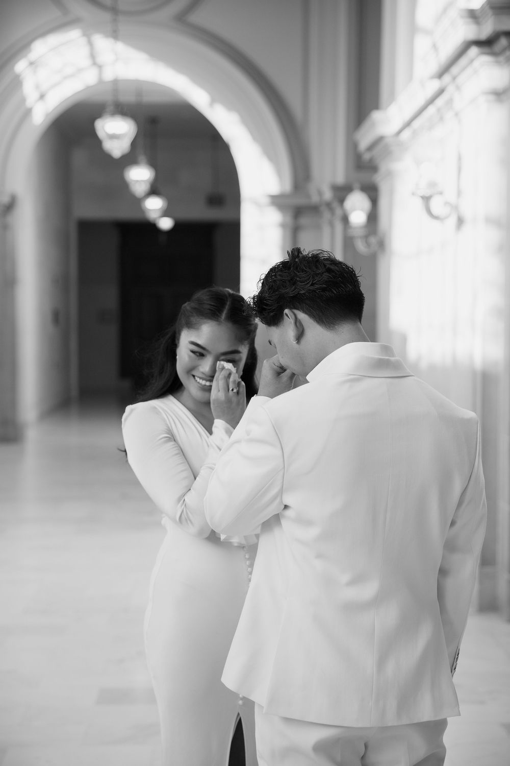 Black and white photo sequence showing couple in white attire sharing an intimate moment in marble hallway.