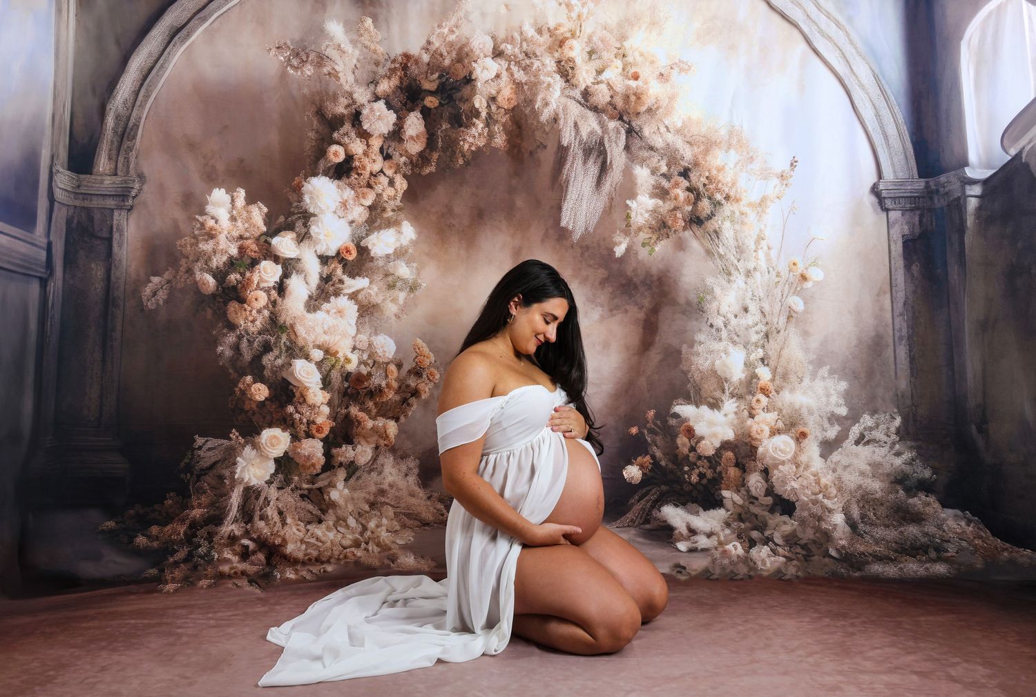 Romantic maternity photos with pink cherry blossoms in a dreamy setting.