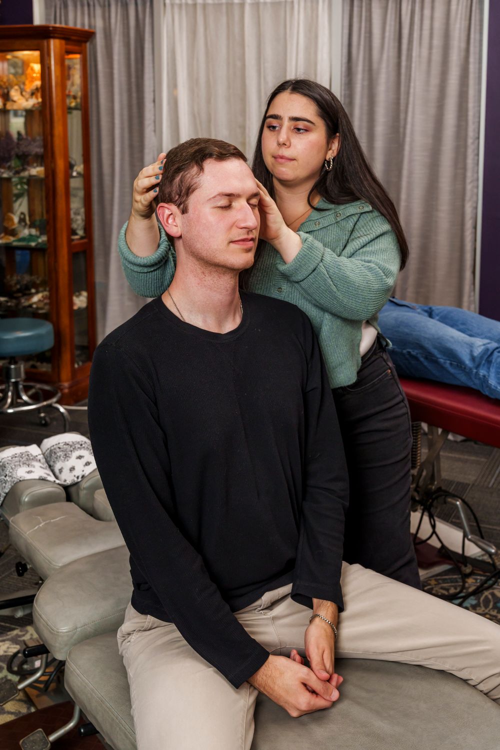 Healthcare provider performs gentle neck manipulation during therapeutic session.