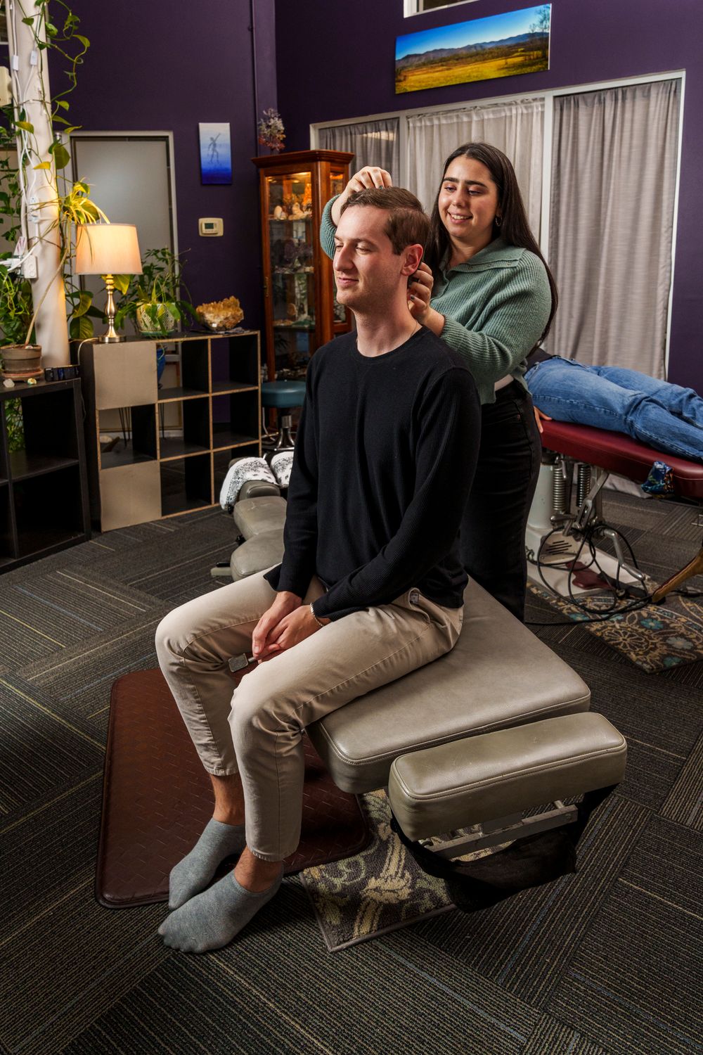 Patient receives professional chiropractic care while seated on treatment table.