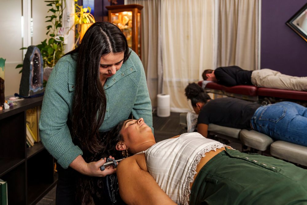 Chiropractor performing therapeutic treatment on patient lying on massage table in wellness clinic.