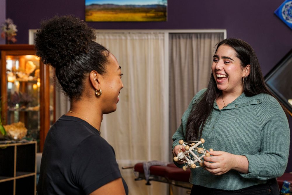 Two healthcare professionals sharing a joyful moment while consulting in medical office.