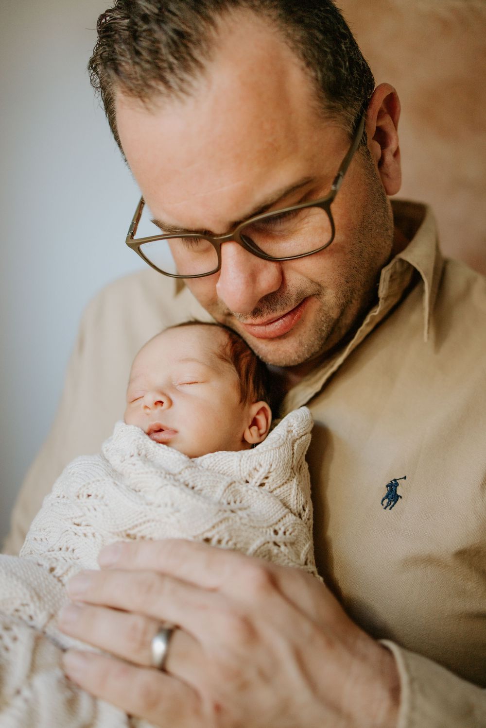 Father holding newborn in home photo session in Adelaide