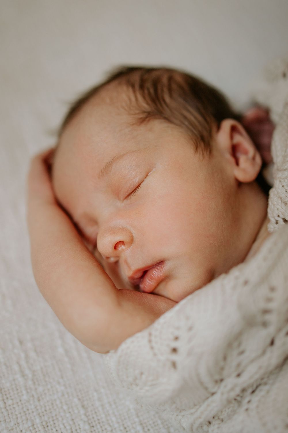 In-home newborn photoshoot in Adelaide with a peaceful, sleepy baby in natural light