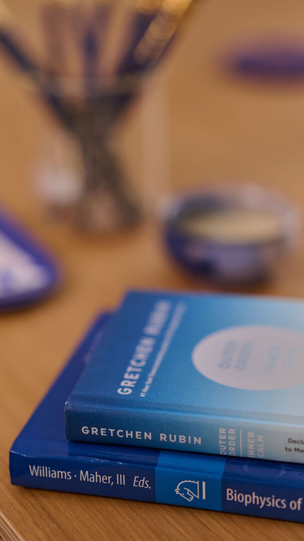 Blue hardcover textbooks arranged in a row on a wooden surface with changing focus across multiple books.