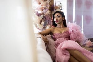 Canberra Model and Bollywood Actress Sadia wearing a pink gown on a couch at the Canberra Fair.