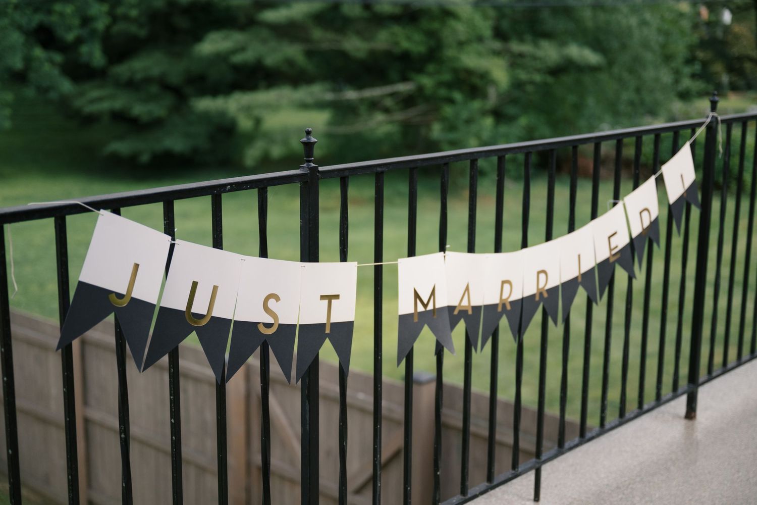 White banner decorations hanging along a black metal railing at an outdoor event.