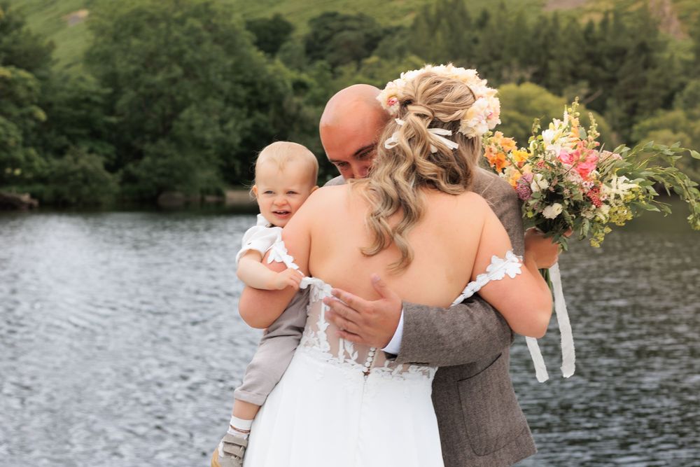 A romantic lakeside wedding moment with fall flowers and a beautiful natural backdrop over water.