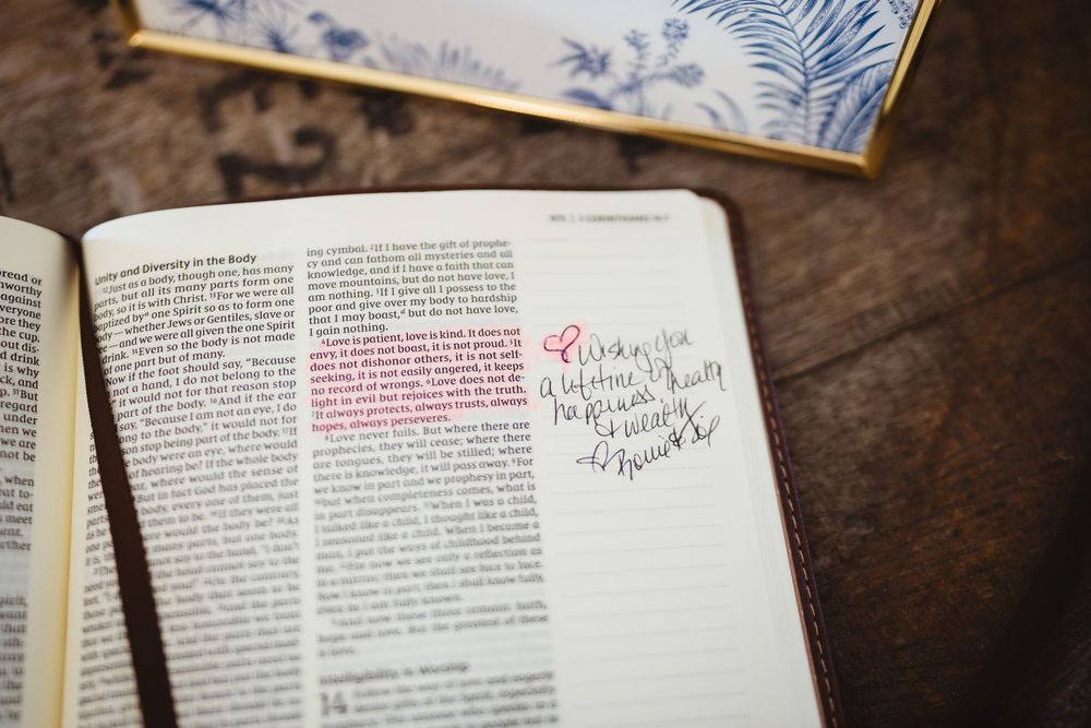 Open book with highlighted text and handwritten notes on dark wooden surface.