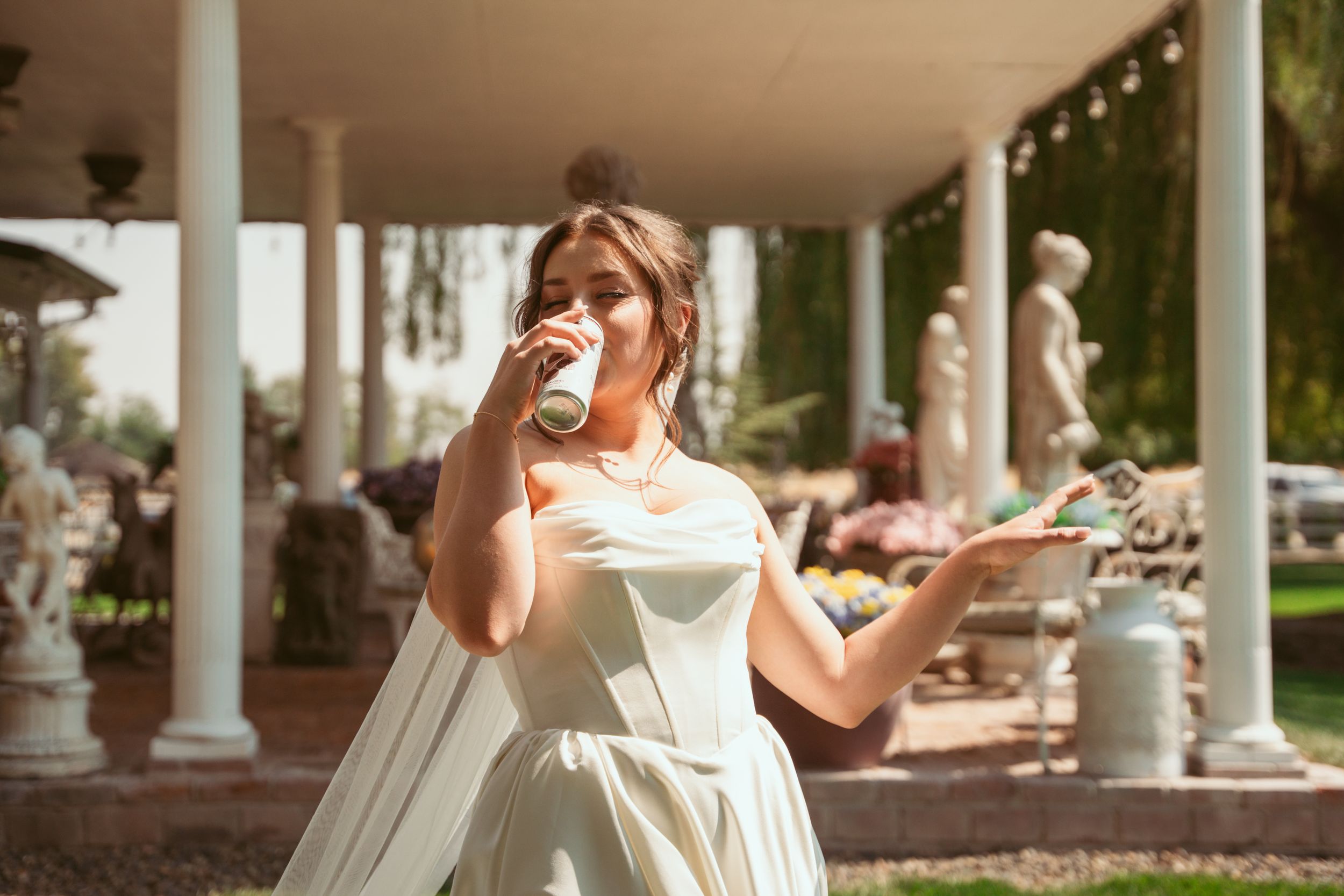 A bride in an elegant white dress poses for photos in various romantic outdoor settings at a wedding venue.