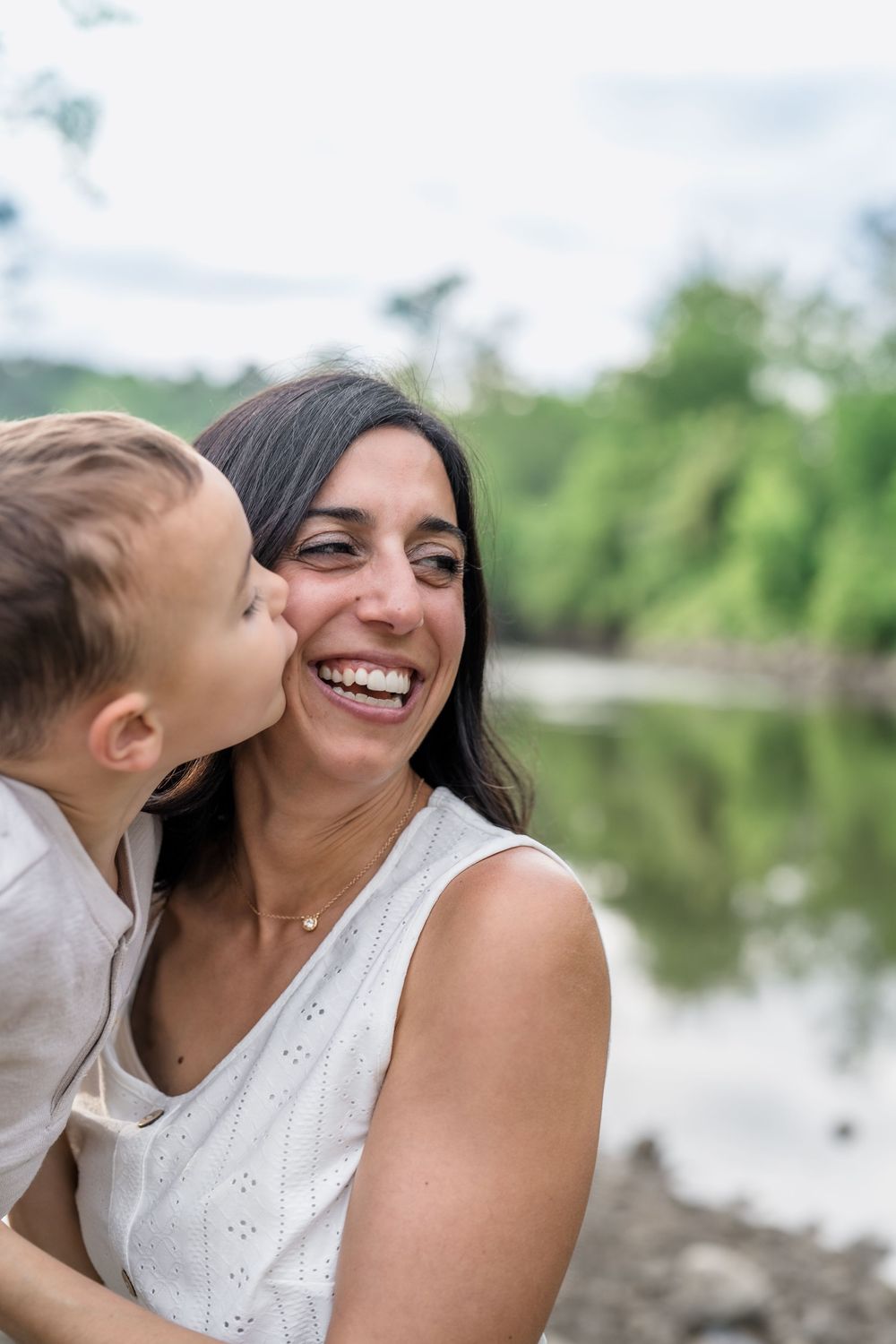 Candid moments of joy and laughter captured by a lake with natural lighting and scenic backdrop at Cleveland's Brecksville Reserve
