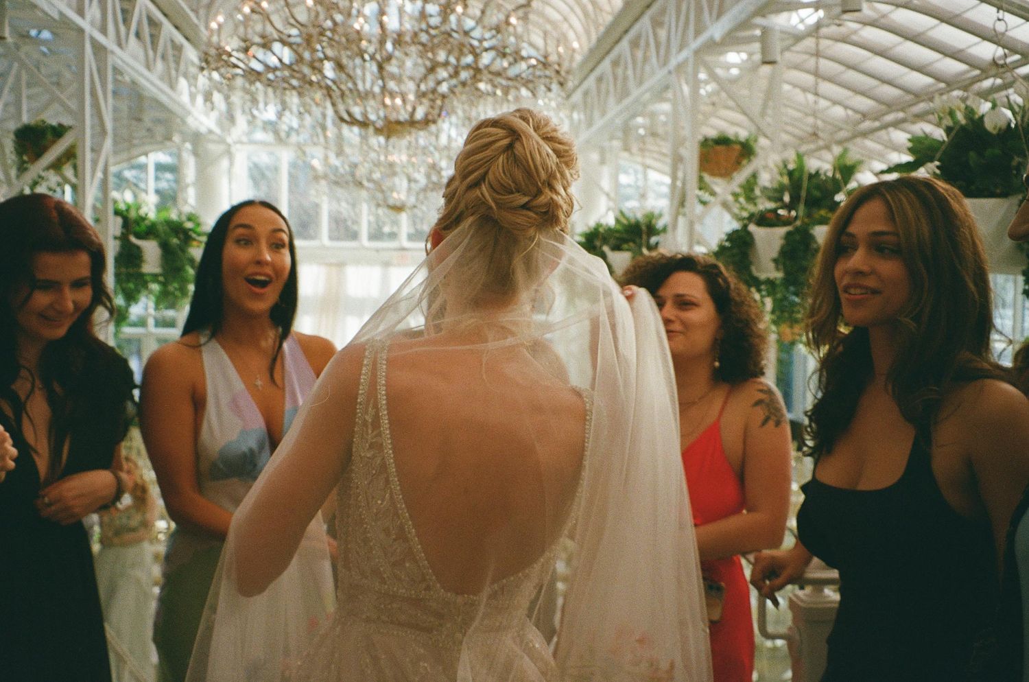 Wedding reception scene with guests and bride in an elegant indoor venue.
