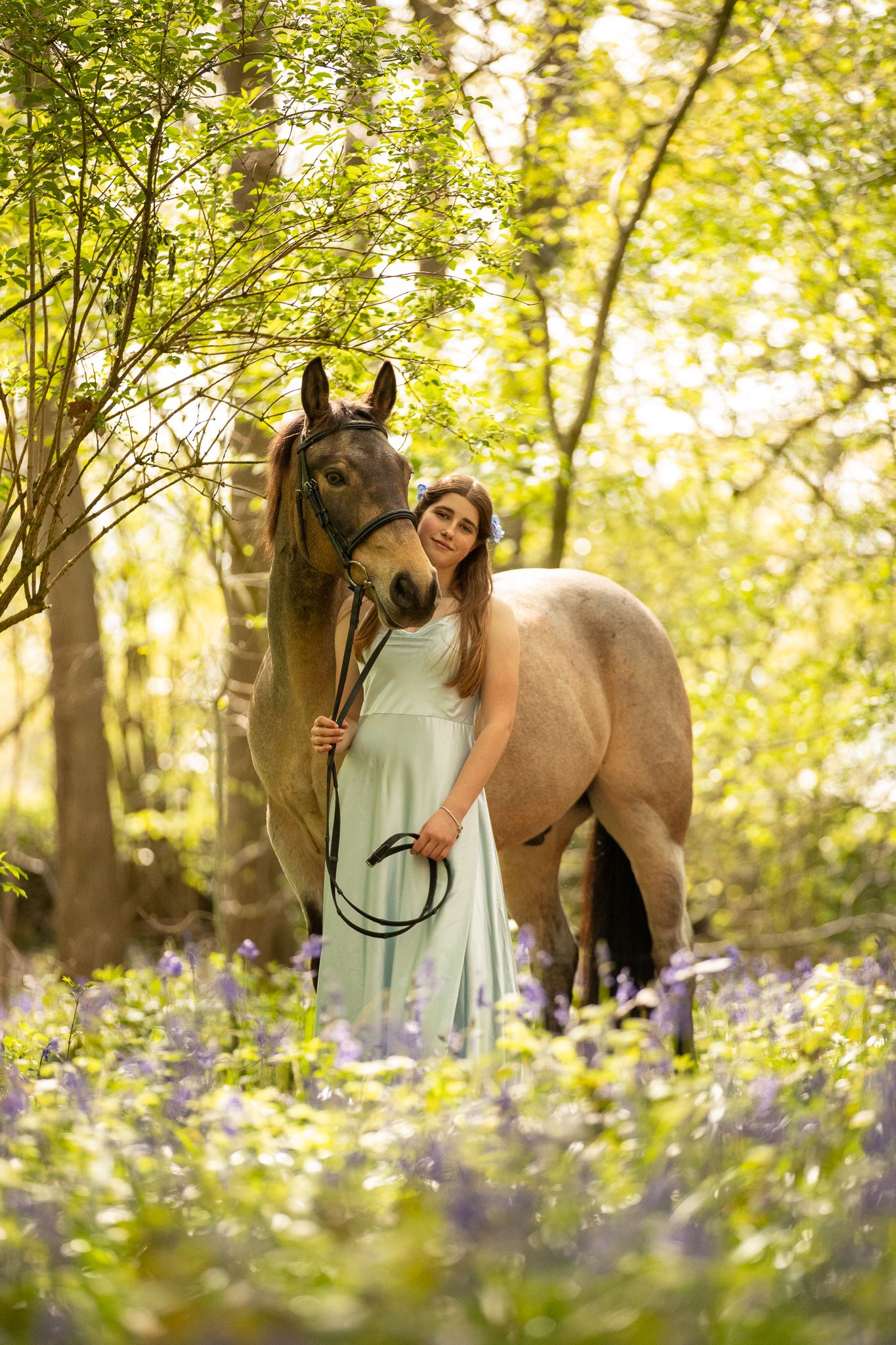 Young equestrian poses with palomino pony in a series of natural outdoor portraits showing their special bond.