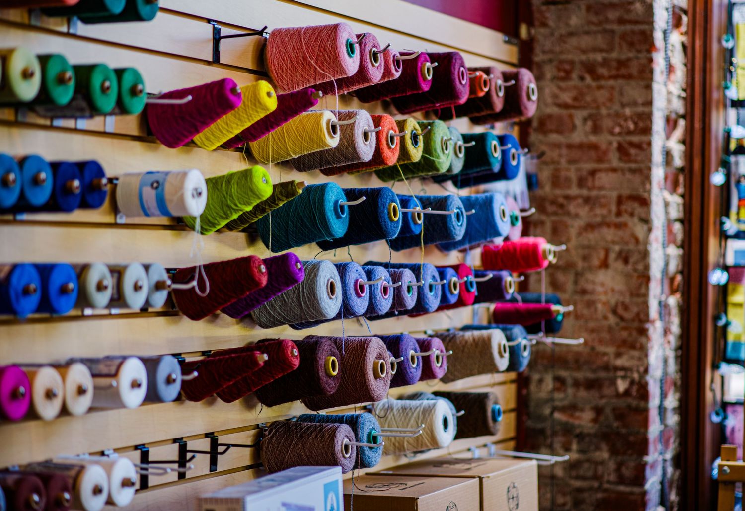 Colorful spools of yarn displayed on a wooden wall in a craft store. Bellingham wa