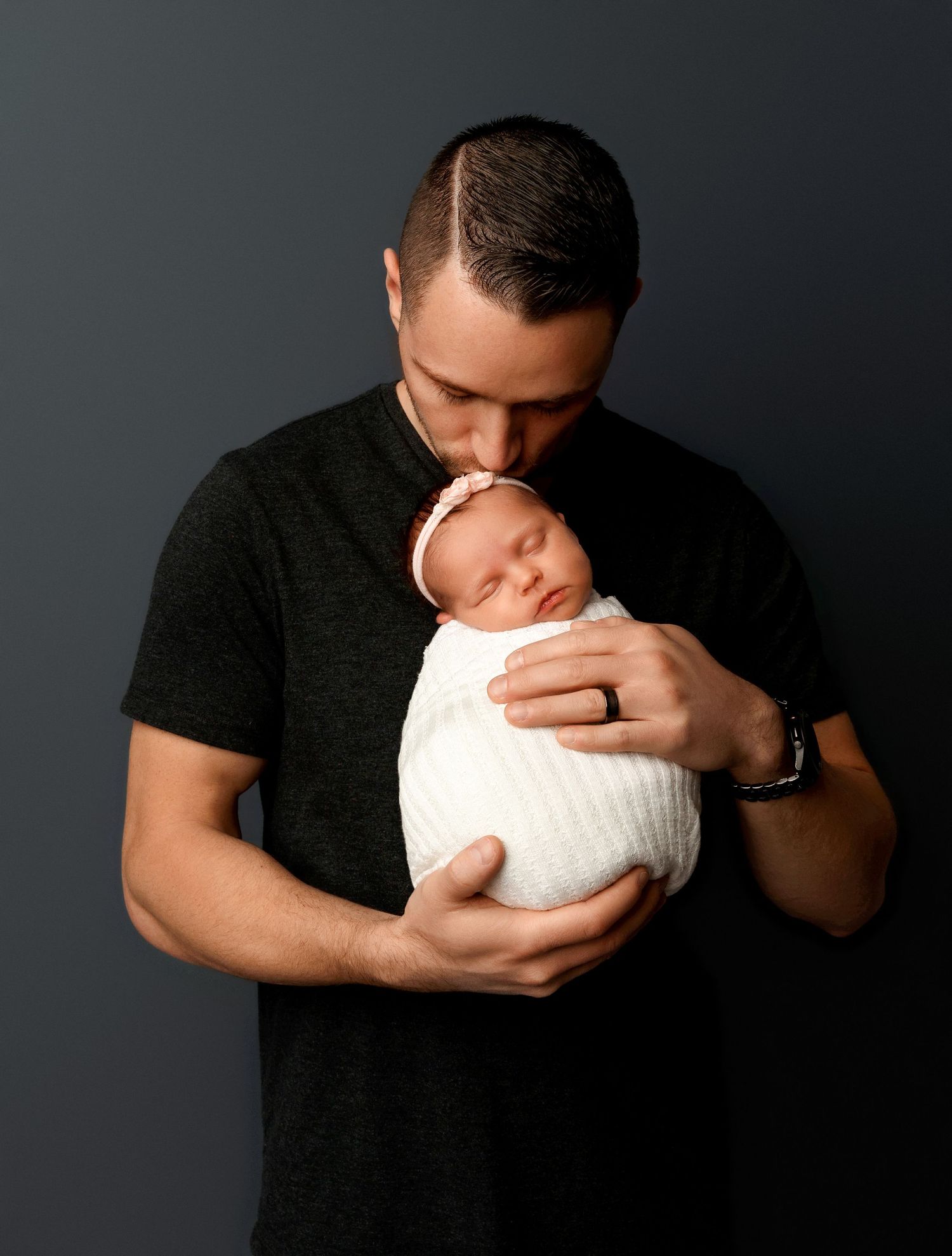 Dad holding their newborn for a newborn session at Stephanie Ann Photography's studio in New Hampshire