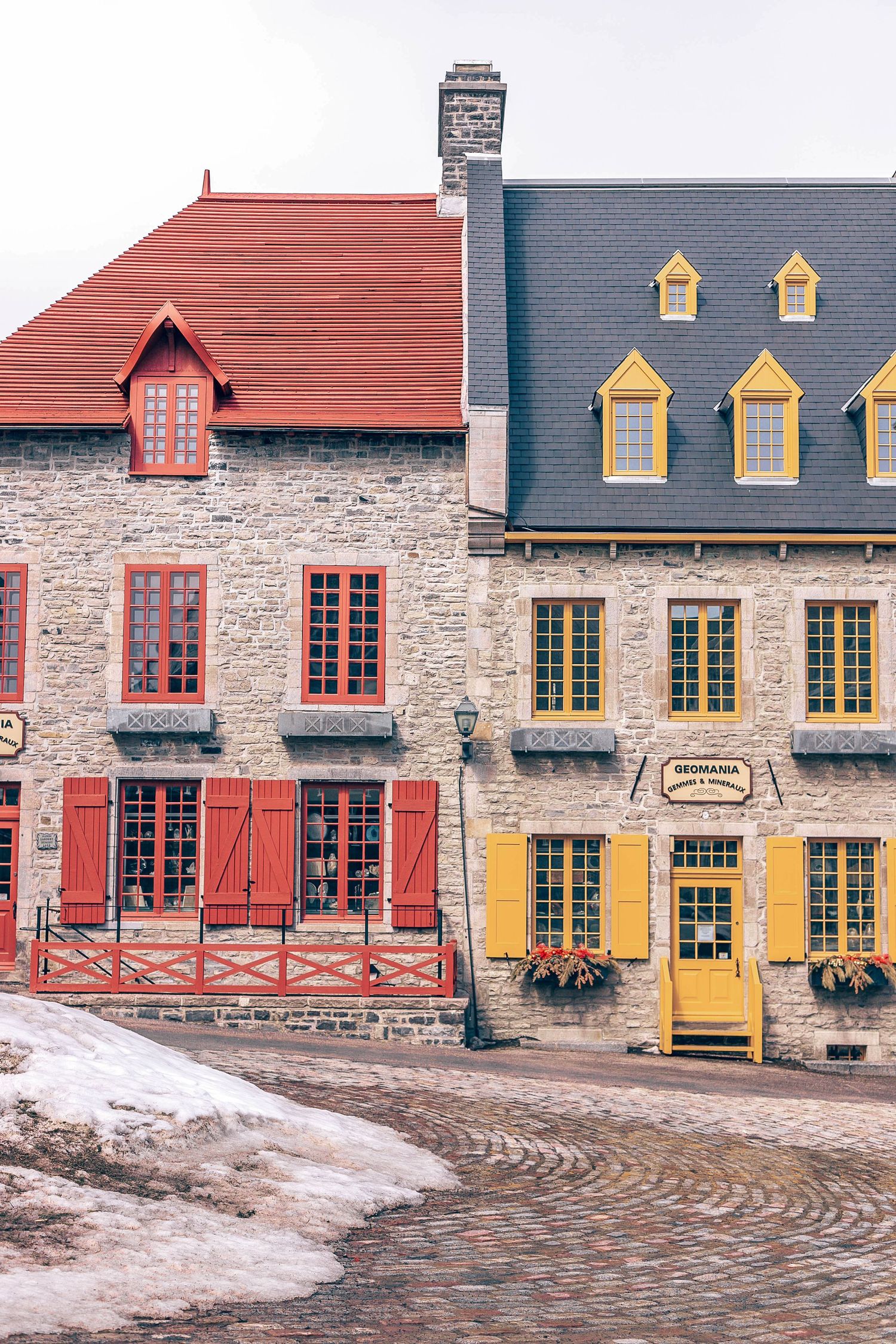 Colorful historic buildings with distinctive architecture featuring red and yellow facades in Quebec City.