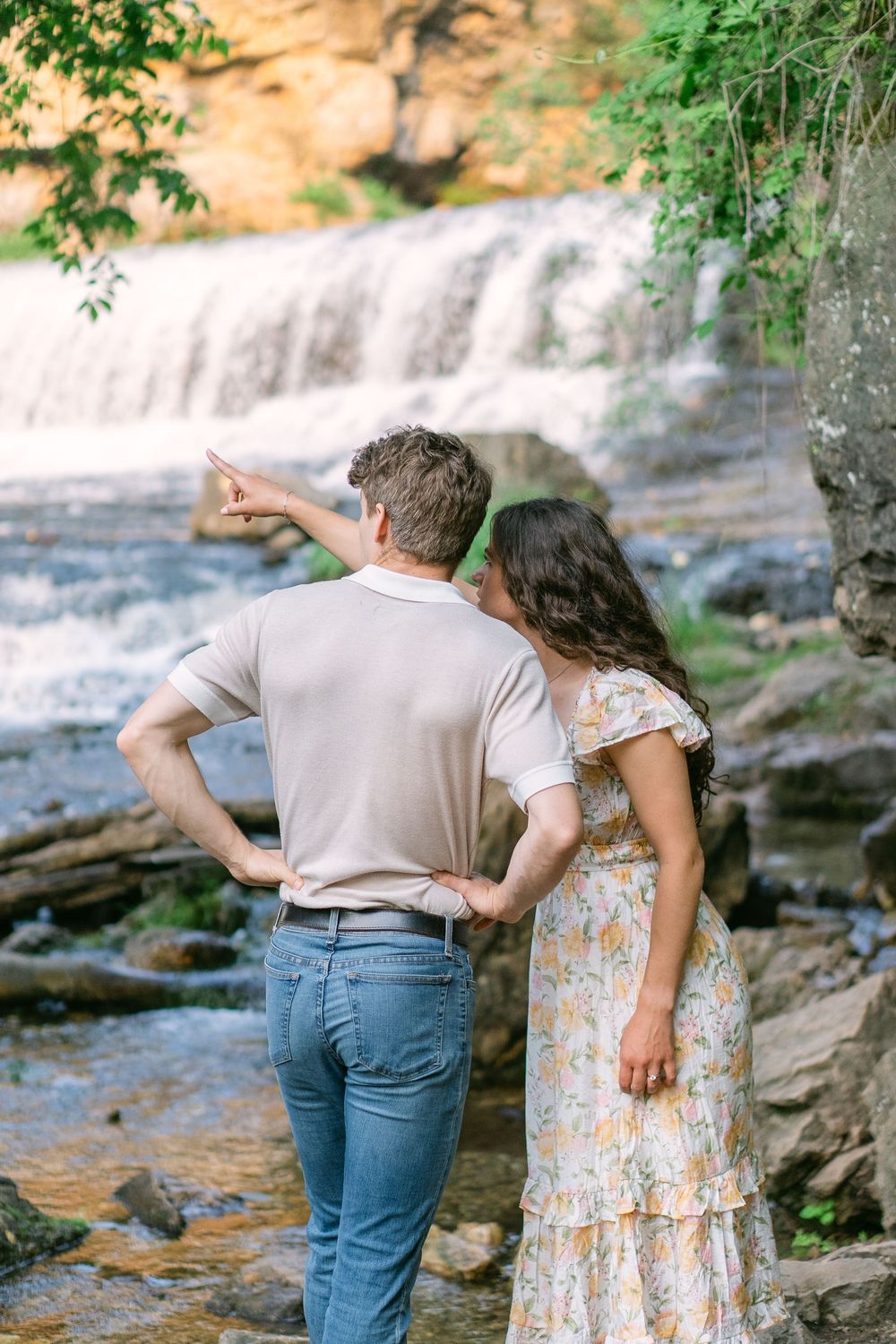 Couple framed by leaves, smiling and touching noses as they share a sweet moment at Willow River State Park