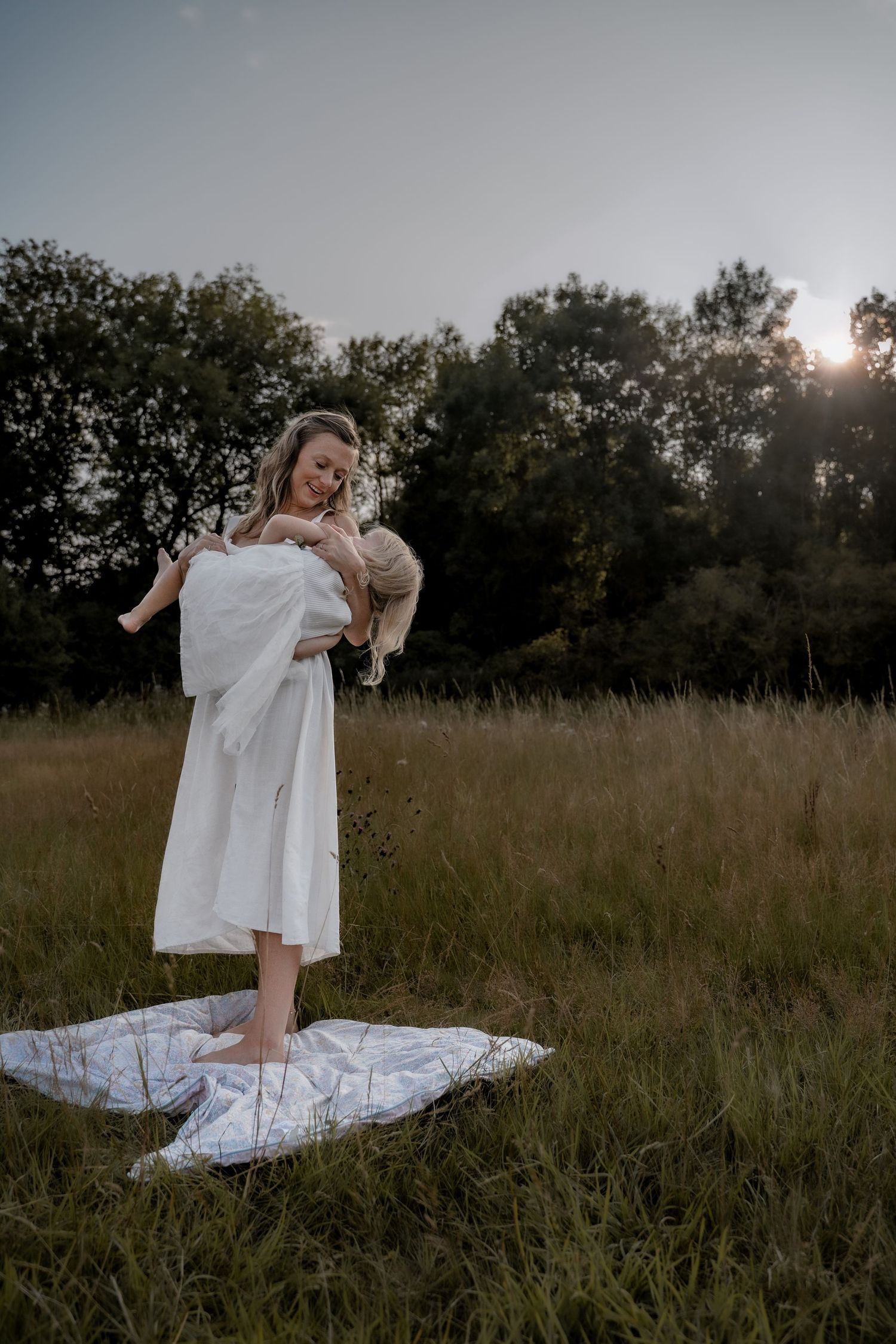 Mother holding her child close in soft evening light, captured by Moments by Simona.