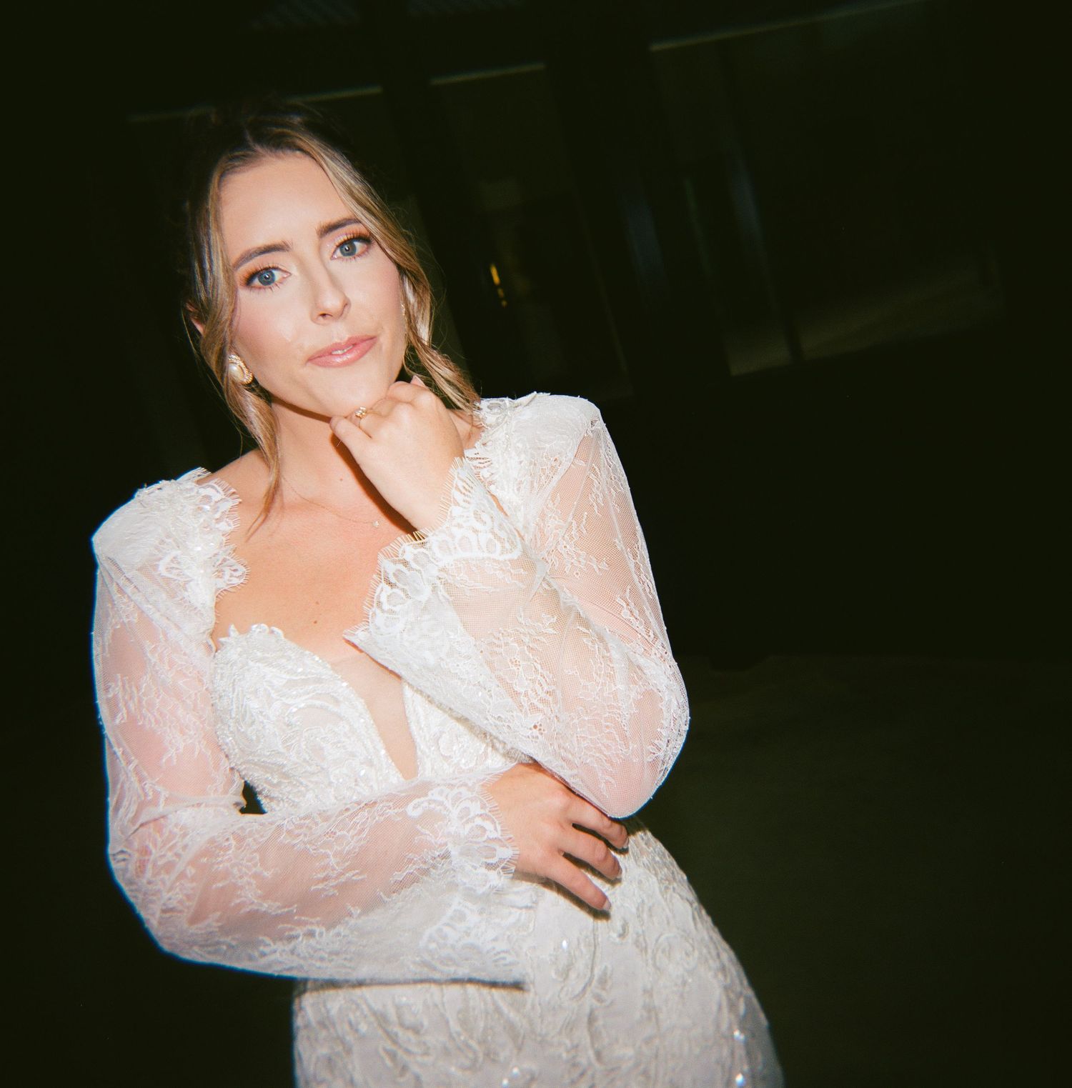 Person in a white lace dress with sheer puff sleeves poses against dark background in multiple candid shots.