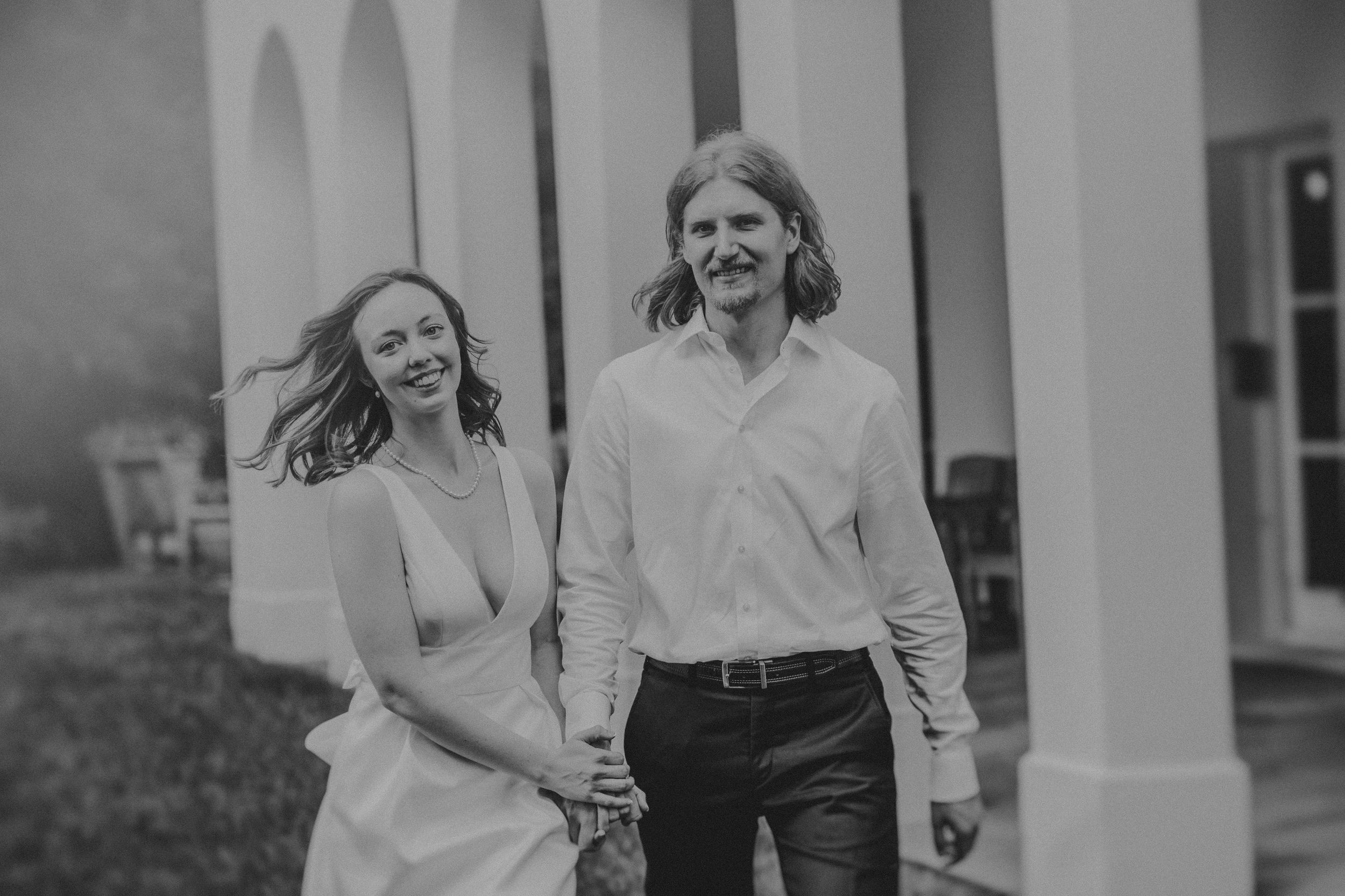 Black and white wedding photos show intimate moments between a couple walking and embracing outdoors.