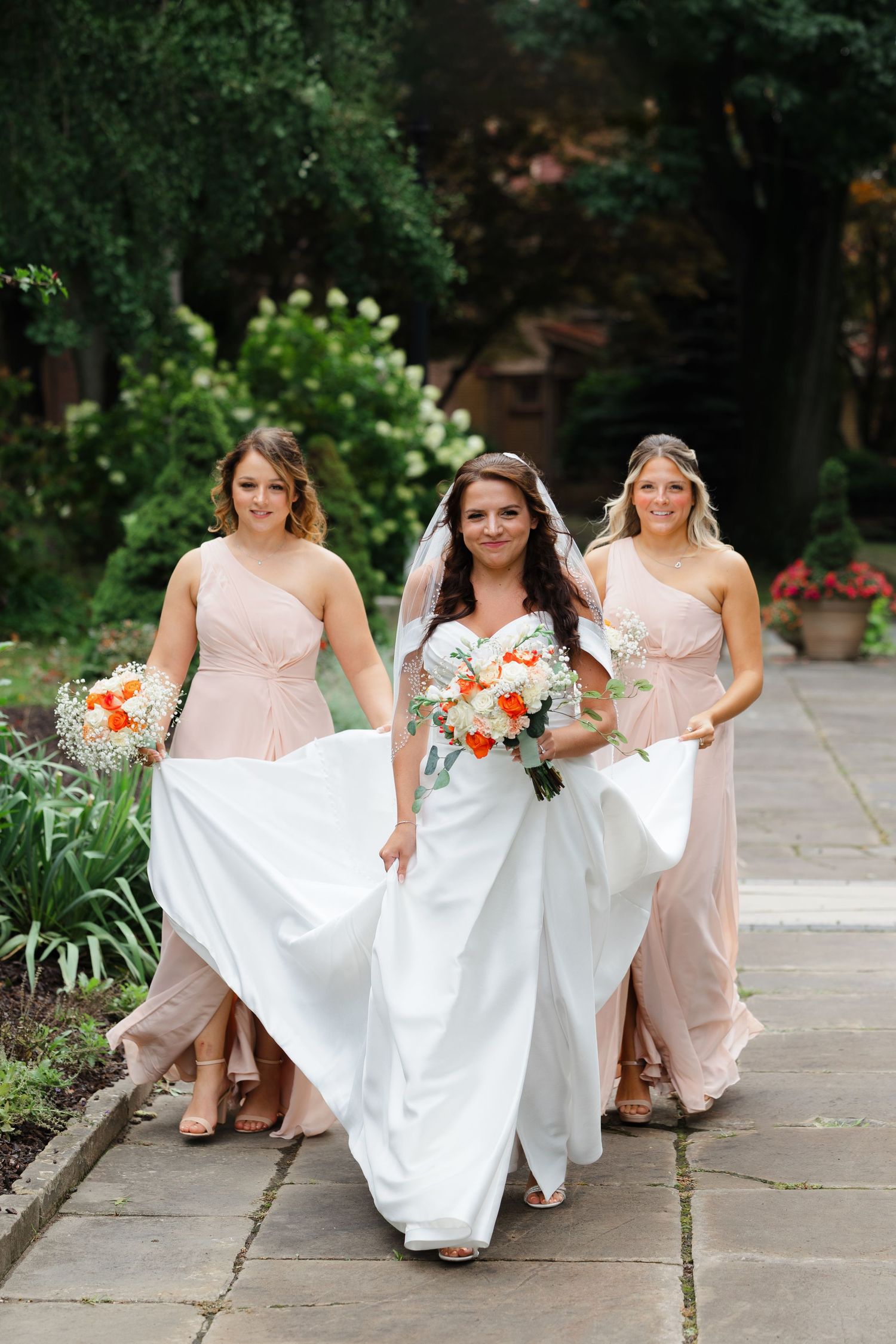 Bride walking with bridesmaids at Cleveland Cultural Gardens.