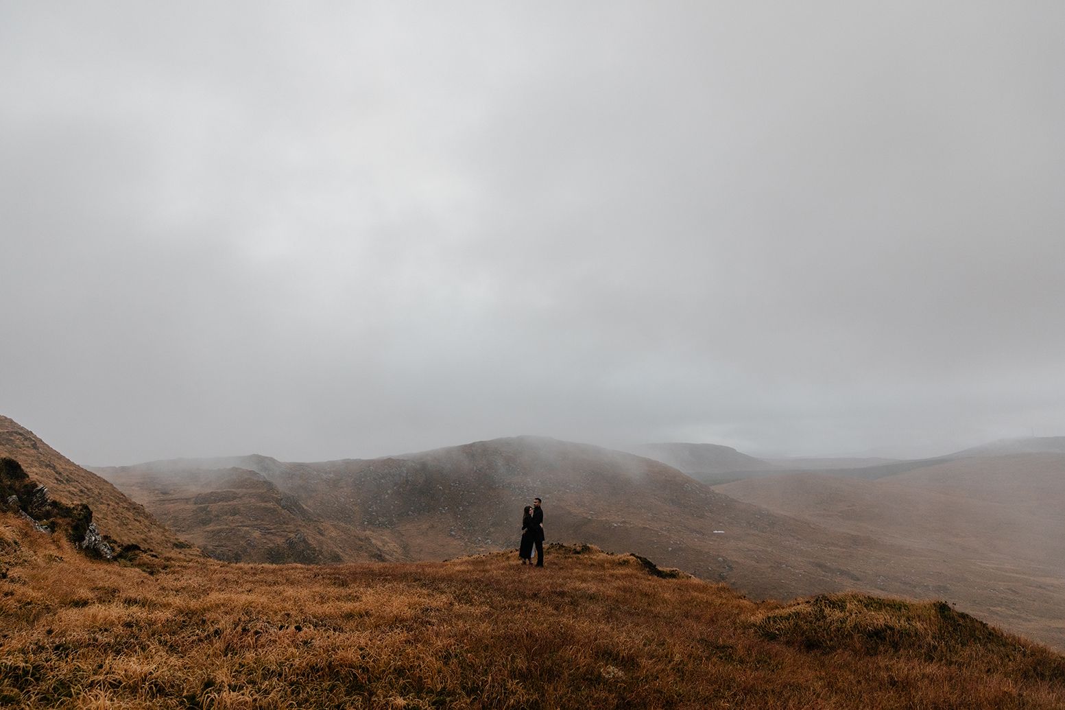Adventure couple session on Diamond Hill in Connemara with misty mountains and soft light