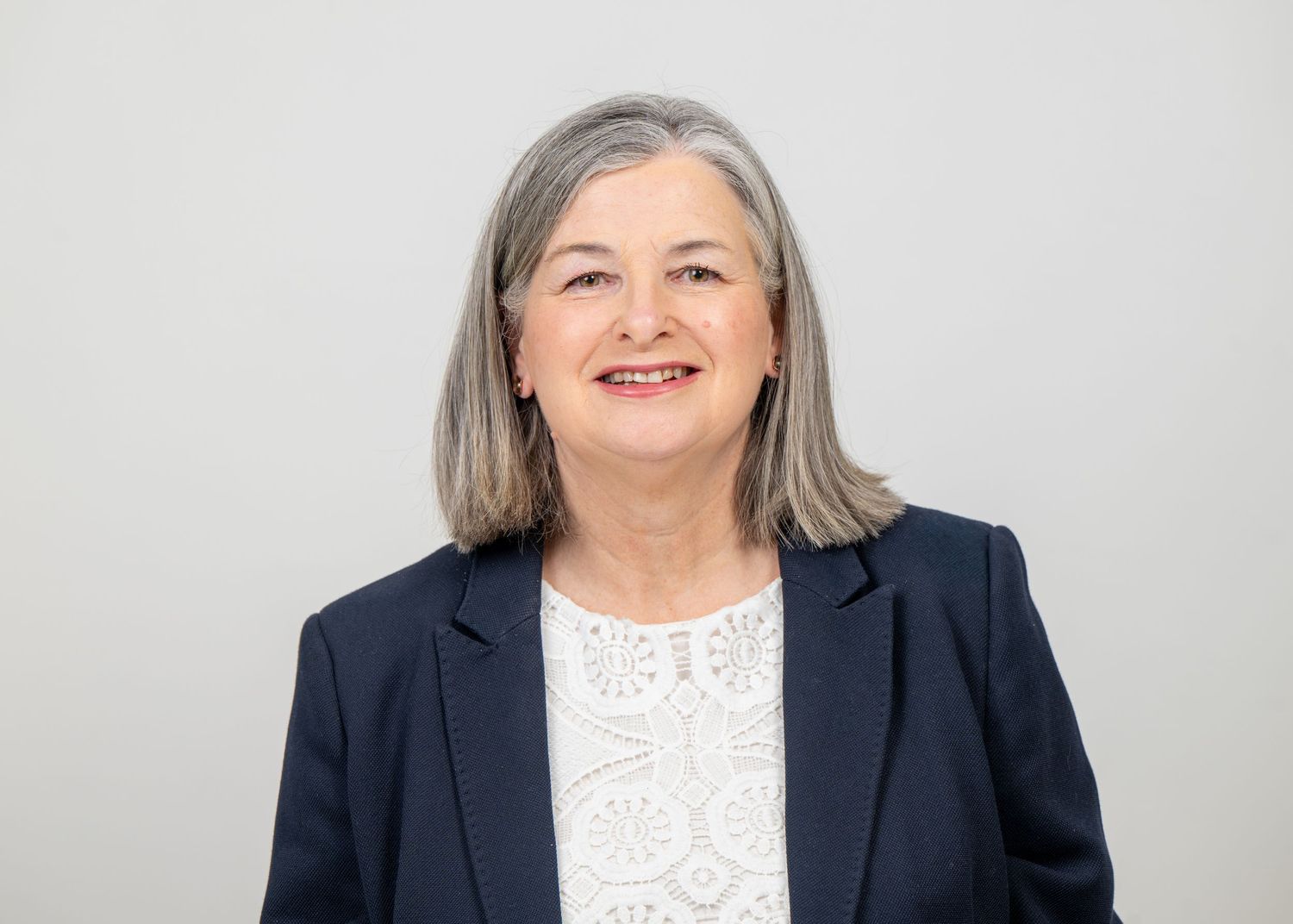 Professional headshot series showing same person in business attire with white lace blouse against light background barnsley