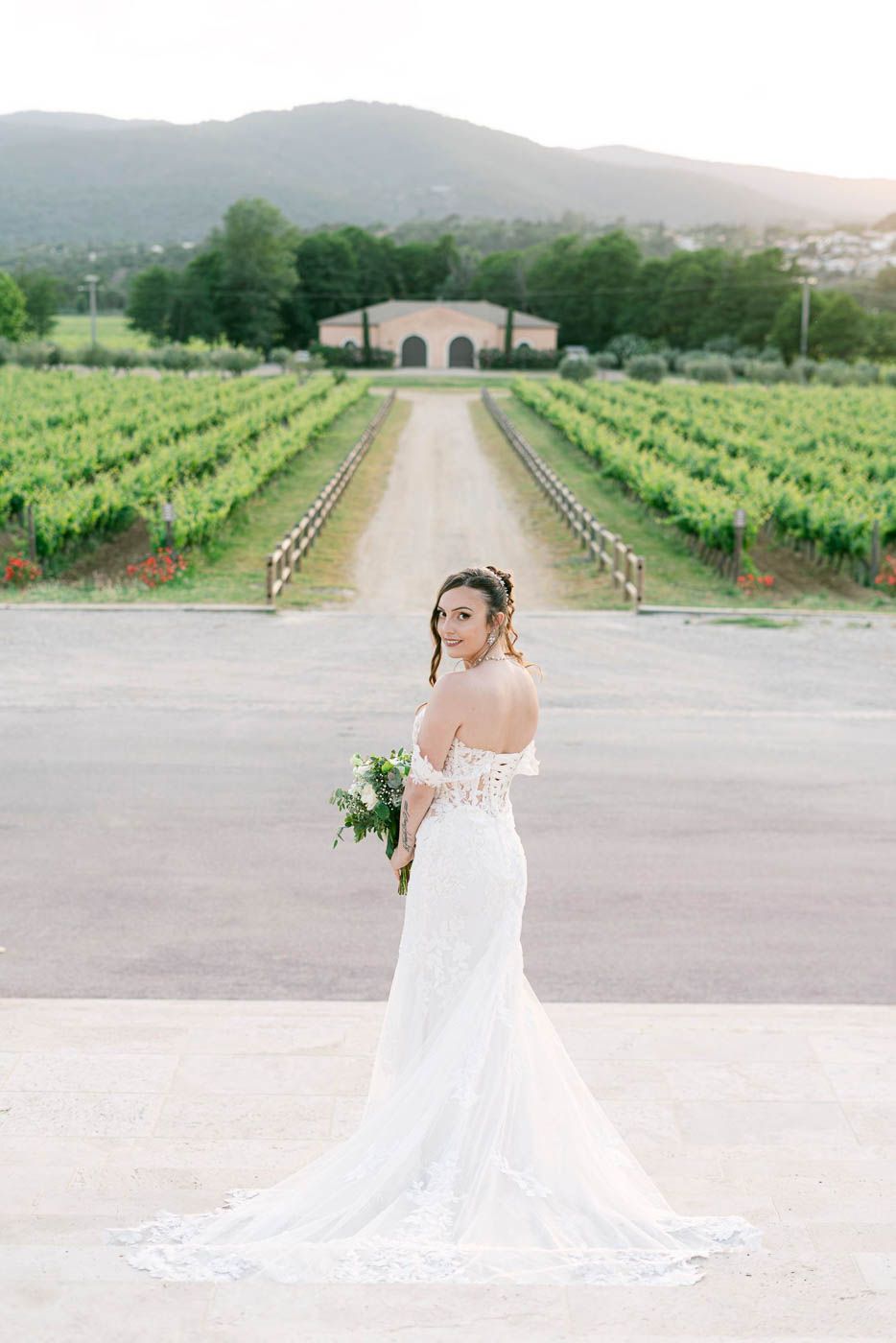 Mariée seule devant des vignes, portrait fine art au domaine, lumière naturelle et élégante.