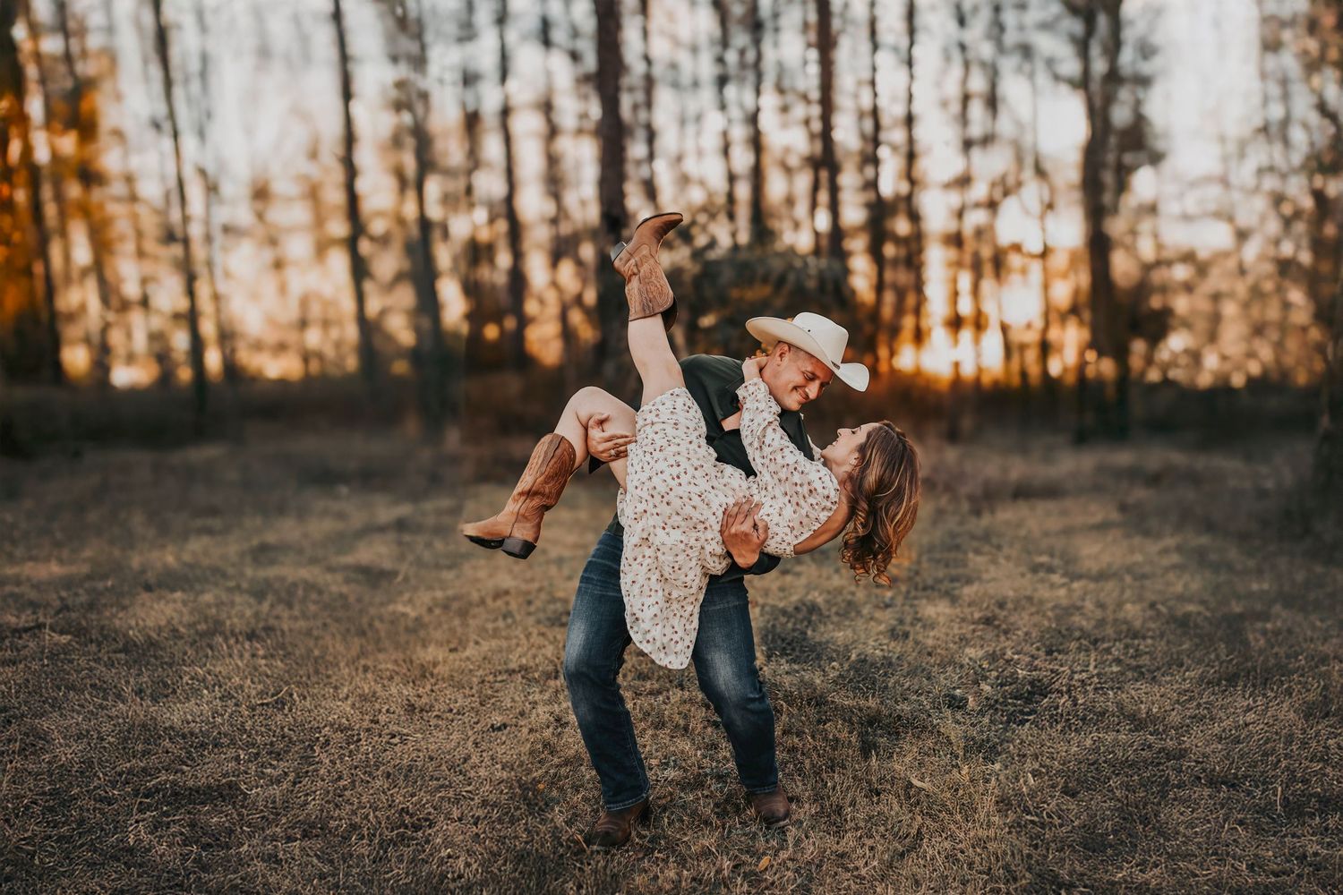 Cowboy dipping his fiancée during an engagement session in the woods at Parker Rose Garden