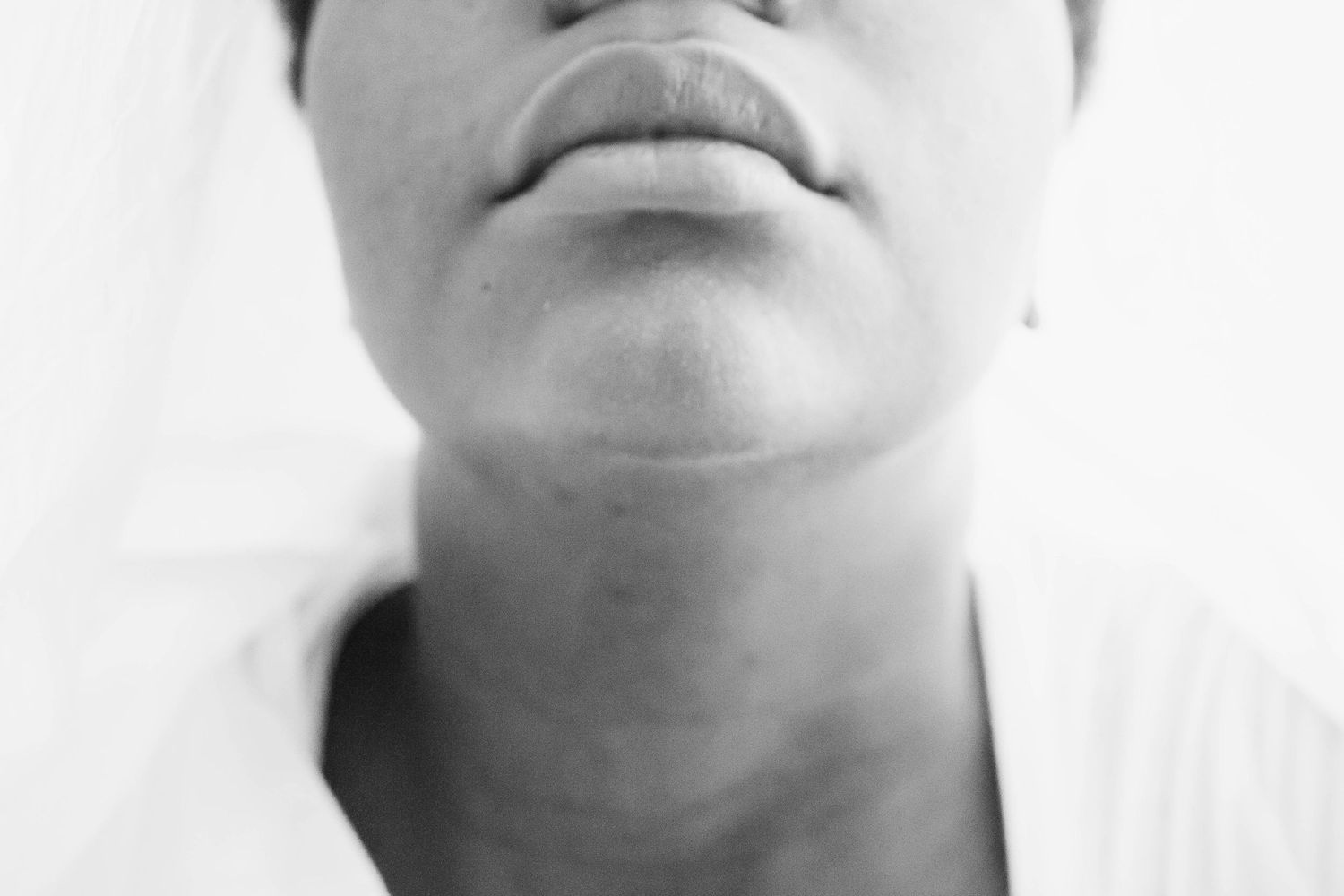 Four black and white close-up photos showing different facial expressions and mouth positions in sequence.