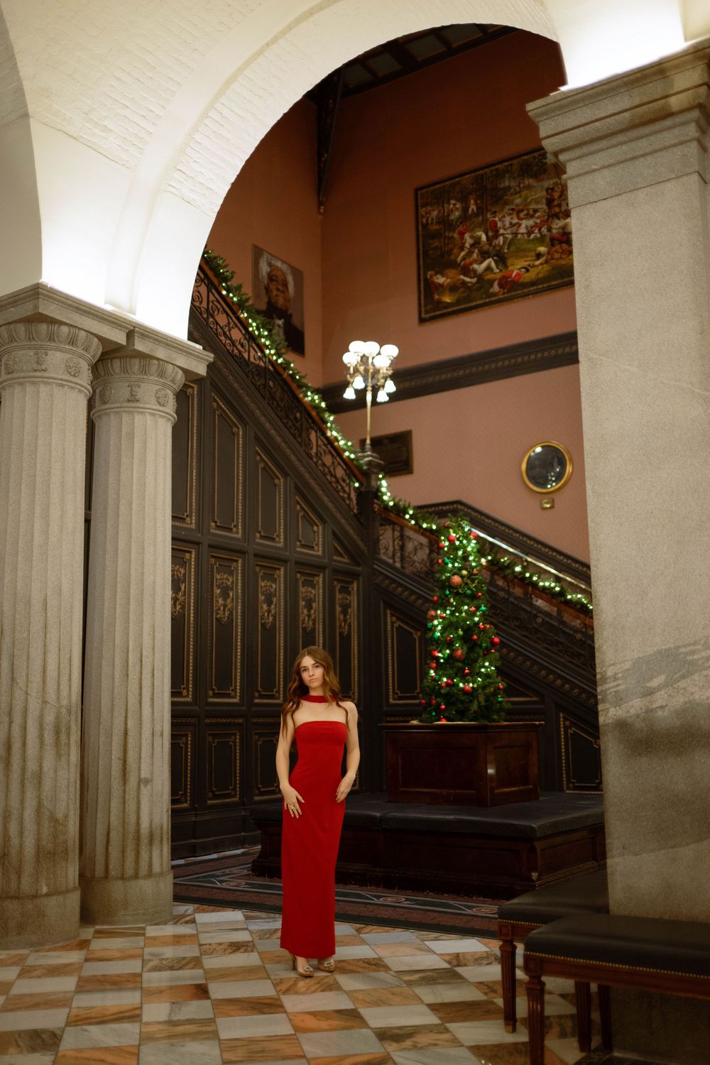 A girl poses underneath and archway dressed elegantly