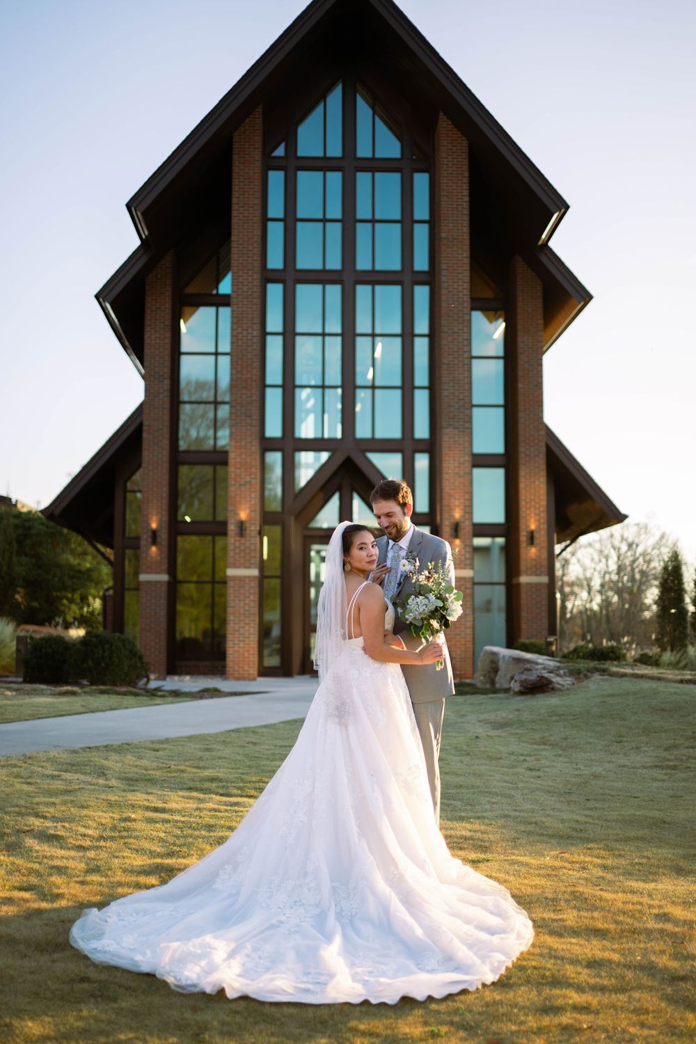 bride and groom standing in front of the chapel