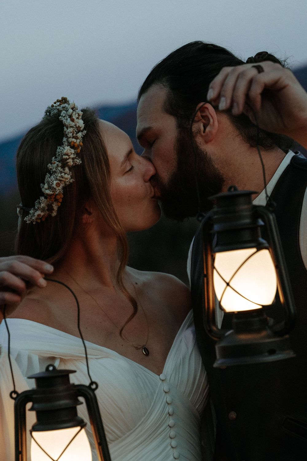 bride and groom lean in for a kiss in front of the mountains