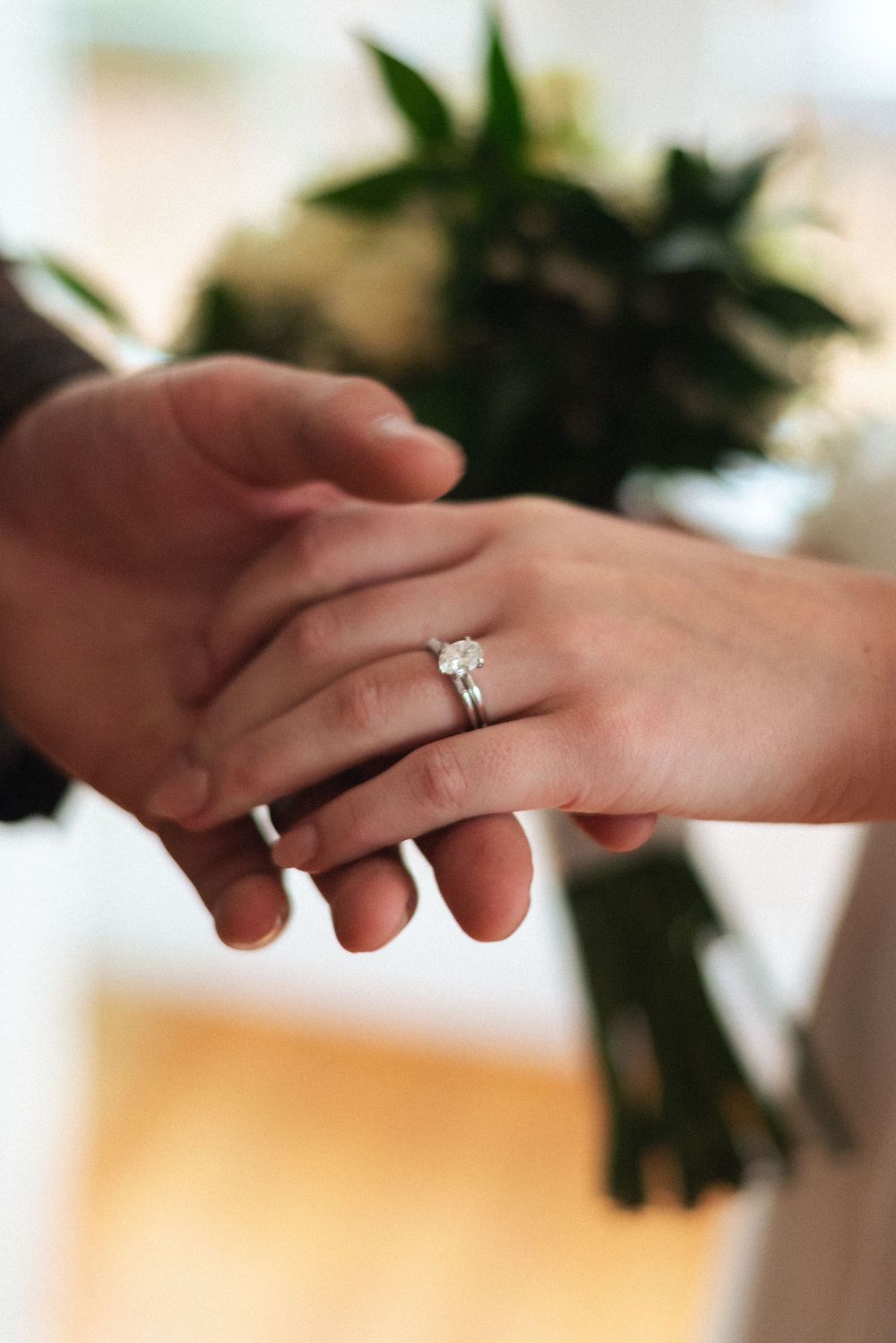 bride and groom holding hands showing off engagement ring