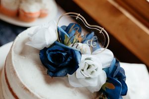 Navy blue and white silk flowers arranged in a decorative bouquet with delicate ribbons and stems.