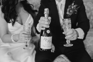 Wedding guests raise champagne glasses in a celebratory toast at an elegant reception.
