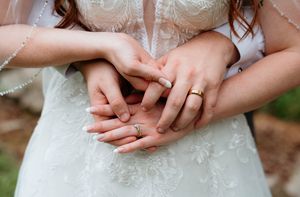 Close-up detail shots of hands with wedding rings and delicate white lace dress details.
