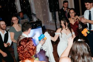 A group of people dancing and celebrating at a lively party or event in a dimly lit room.