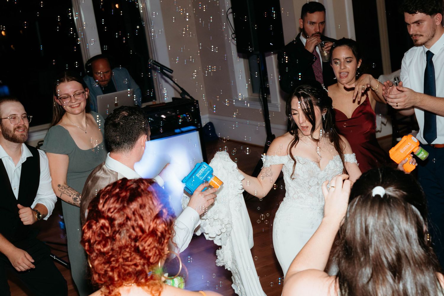 A group of people dancing and celebrating at a lively party or event in a dimly lit room.