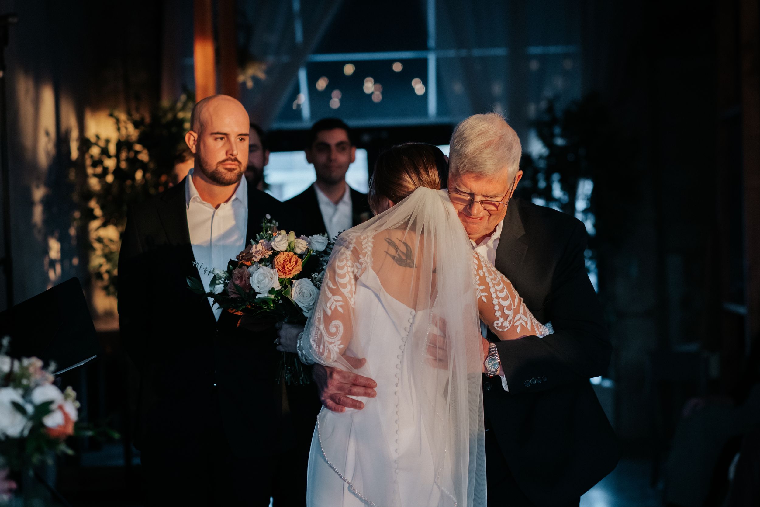 Wedding ceremony candid moments captured in a modern industrial space.