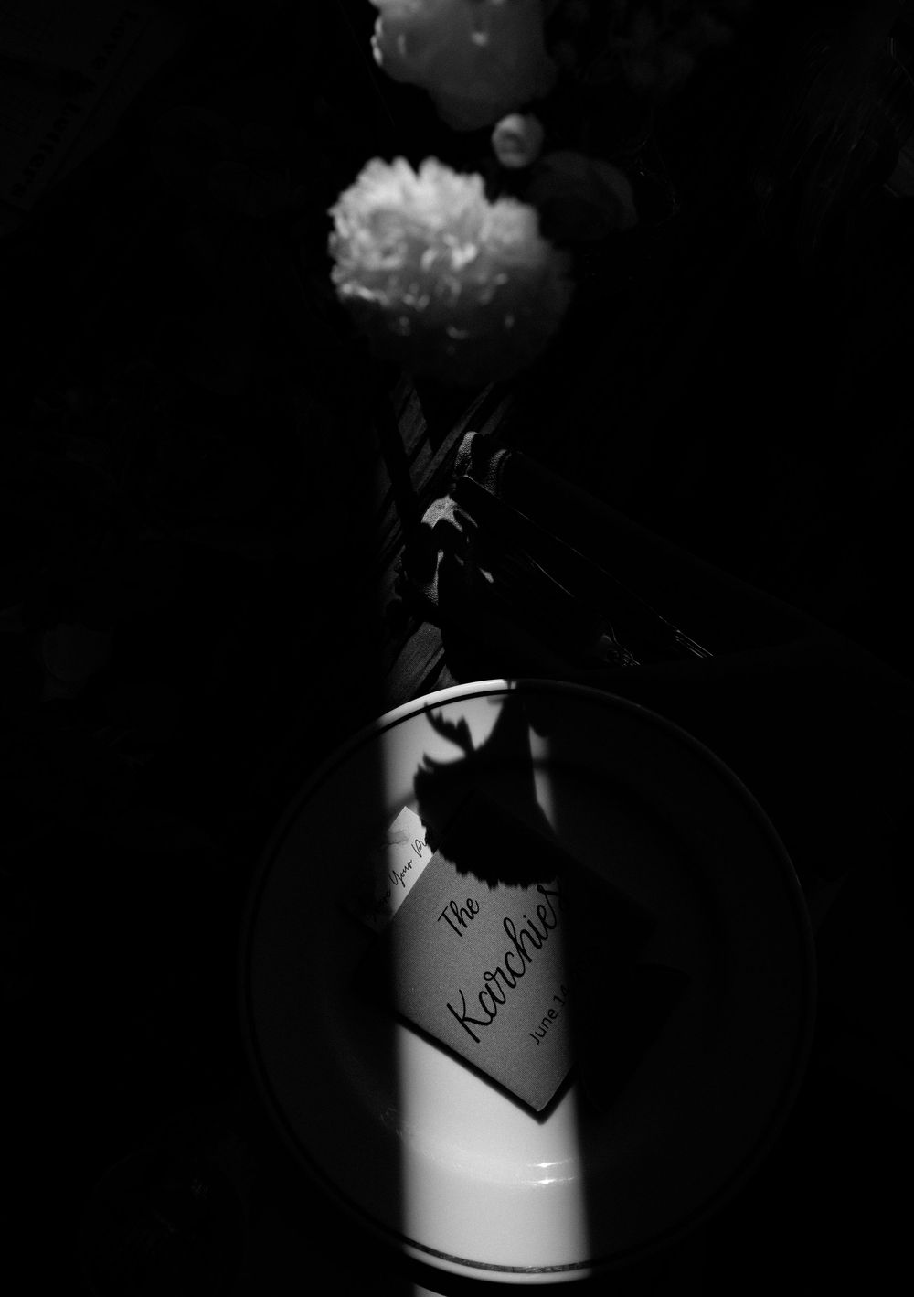 Artistic black and white close-up shot of champagne bottles in low light.